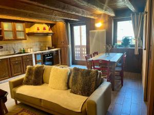 ein Wohnzimmer mit Sofa und Tisch in der Unterkunft Tsi nos La Salle appartamento con giardino e balcone in La Salle