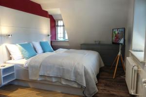 a bedroom with a large white bed with blue pillows at Reethus Haupthaus im EG OG in Borgsum