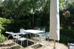 a white table and chairs sitting on a patio at Reethus Haupthaus im EG OG in Borgsum