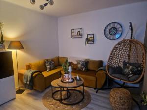 a living room with a couch and a hanging chair at PIK-Kwatery in Morąg