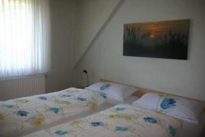 a bedroom with two beds and a painting on the wall at Pidder Lyng - FW 3 in Utersum