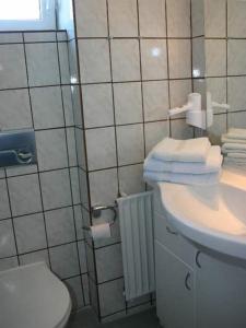 a bathroom with a toilet and a sink with towels at Pidder Lyng - FW 3 in Utersum