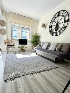 a living room with a large clock on the wall at Beachome4u in Carcavelos