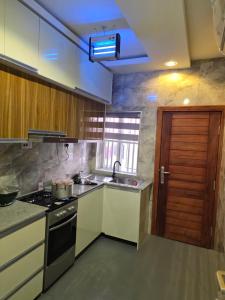 a kitchen with a sink and a stove at BJ Home in Iseri-Oke
