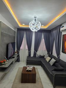 a living room with a black couch and a chandelier at BJ Home in Iseri-Oke