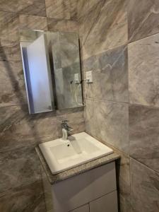 a bathroom with a sink and a mirror at BJ Home in Iseri-Oke +15 photos