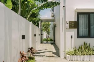 an internal corridor of a building with plants at Domu Alba Vita in Denpasar