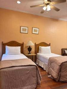 a bedroom with two beds and a ceiling fan at Sophia Suites Residence Hotel in Cebu City