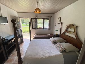 a bedroom with two beds and a desk and a window at Auberge Marcheroux in Amboise