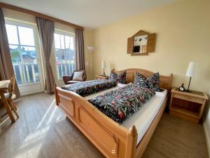 a bedroom with a large bed with colorful pillows at Gästehaus Frankenwaldhof in Bad Steben