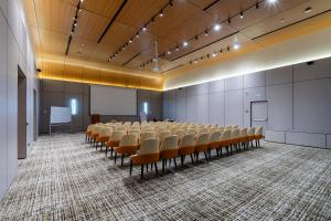 an empty lecture hall with chairs and a podium at Renion Almaty Hotel in Almaty +26 photos