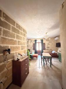 a living room with a table and a brick wall at Ta' Marta Lodge in Victoria