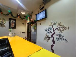 a room with a wall with a tree painted on it at Bhammar's Inn - A Pure Veg in Kolkata