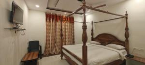 a bedroom with a canopy bed and a television at RUDRAKSH HOTEL & RESTAURANT in Kumbhalgarh in Kumbhalgarh