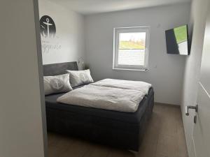 a bed in a bedroom with a window at Ferienwohnungen Hafenwerk in Braunsbedra