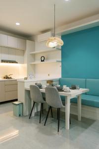 a kitchen with a table and chairs and a blue wall at Domu Alba Vita in Denpasar
