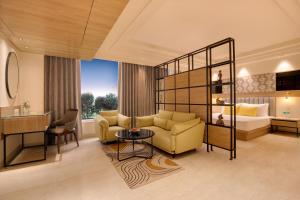 a living room with a couch and a bed at Lemon Tree Hotel, Bhubaneswar in Bhubaneshwar
