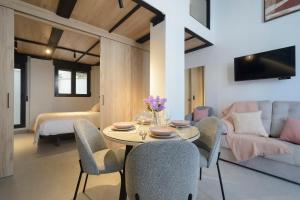 a dining room with a table and chairs and a couch at Apartamentos Nevada Metro con PARKING GRATIS in Maracena