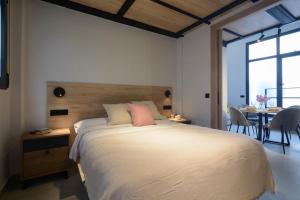 a bedroom with a large bed and a table with chairs at Apartamentos Nevada Metro con PARKING GRATIS in Maracena