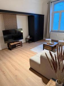 ein Wohnzimmer mit Sofa und Flachbildfernseher in der Unterkunft Hotel Giorgi - Bastogne Centre in Bastogne