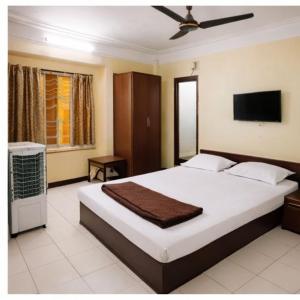 a bedroom with a large bed and a flat screen tv at Hotel amrit in Indore