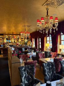 a restaurant with tables and chairs and chandeliers at Riverdam Boutique Hotel in Ilmenau