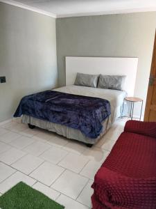 a bedroom with a large bed and a table at Efkay Guest in Thohoyandou