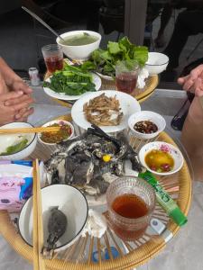 a table with plates of food and bowls of soup at Nhà Nghỉ Mũi Giày in Mù Cang Chải