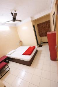a bedroom with a bed with a red blanket on it at Hotel amrit in Indore +1 photo