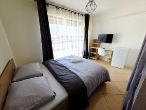a bedroom with a bed with a window and a desk at Chambre B1 in Toulouse