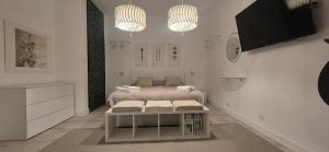 a white bedroom with a bed and a tv at Villa Eura in Pula
