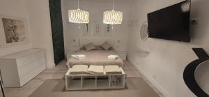 a small white room with a bed and a tv at Villa Eura in Pula
