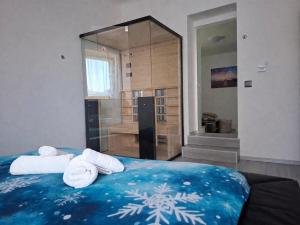 a bedroom with towels on a bed with a shower at Tabor View Apartment with sauna-Free parking in Maribor +58 photos