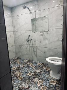 a bathroom with a toilet and a tiled floor at Stay by the Backwater in Kalyānpur