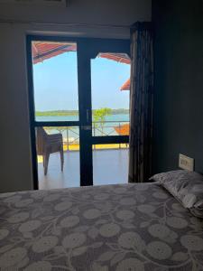 a bedroom with a bed and a view of the ocean at Stay by the Backwater in Kalyānpur