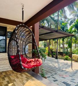 a hammock hanging from a building with a porch at Stay by the Backwater in Kalyānpur