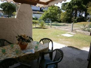 Apartment in Bibione 24437 في بيبيوني: طاولة مع إناء من الزهور على الفناء