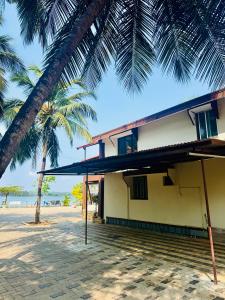 a building on the beach with a palm tree at Stay by the Backwater in Kalyānpur +27 photos