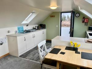 a kitchen with a table and a dining room at Skye Getaways Self Catering Accommodation in Dunvegan
