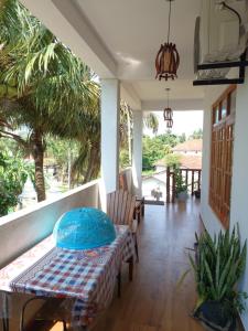a porch with a table and chairs on a porch at New planet guest in Mirissa
