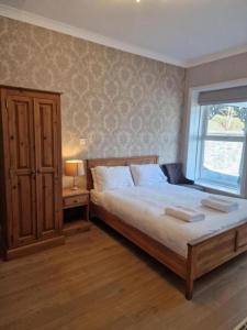 a bedroom with a large bed and a window at Broadway Country House in Laugharne