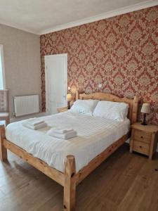 a bedroom with a large bed with a wooden frame at Broadway Country House in Laugharne