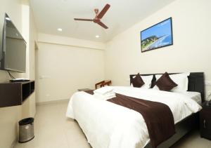 a bedroom with a bed and a ceiling fan at ADITYA BEACH SUITES in Visakhapatnam
