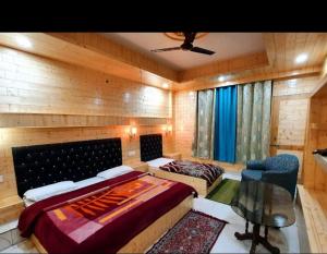 a bedroom with two beds and a ceiling fan at Raj Palce in Kasol