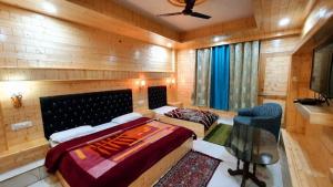 a bedroom with two beds and a desk and a television at Raj Palce in Kasol