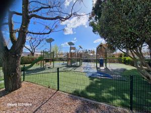 a playground in a park with a fence at Valras Jasmin 68 in Sérignan