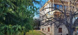 a stone building with trees in front of it at Stone house with seaview in Nea Potidaea