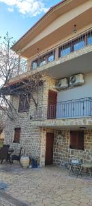 a large brick building with a balcony and a patio at Stone house with seaview in Nea Potidaea