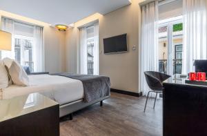 pokój hotelowy z łóżkiem i telewizorem w obiekcie Hotel Santa Justa w Lizbonie