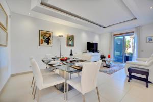 a dining room with a table and white chairs at Villa Magnolia The Crest 3 quartos e piscina in Almancil